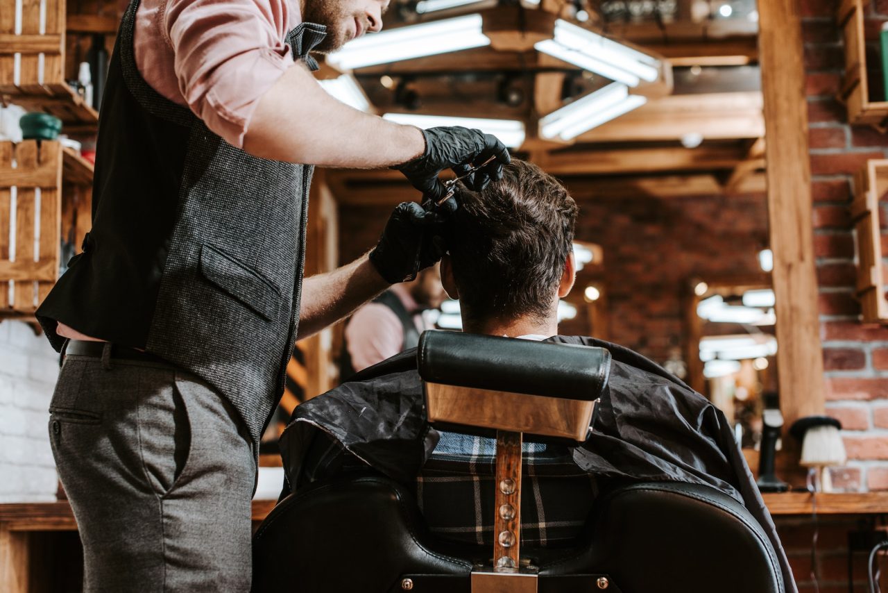 bearded-barber-cutting-hair-of-man-in-barbershop.jpg